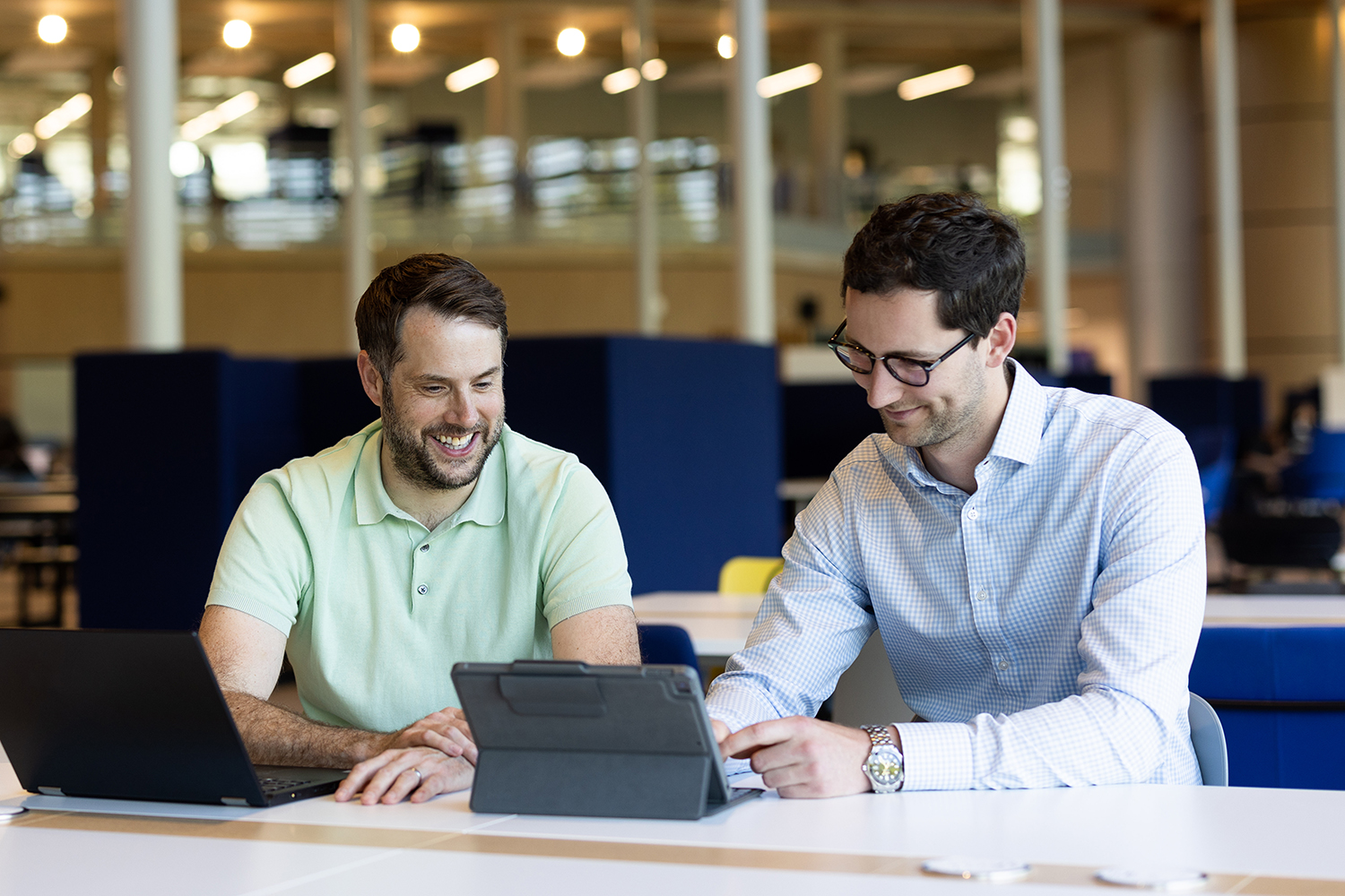 Two students sitting looking at a laptop